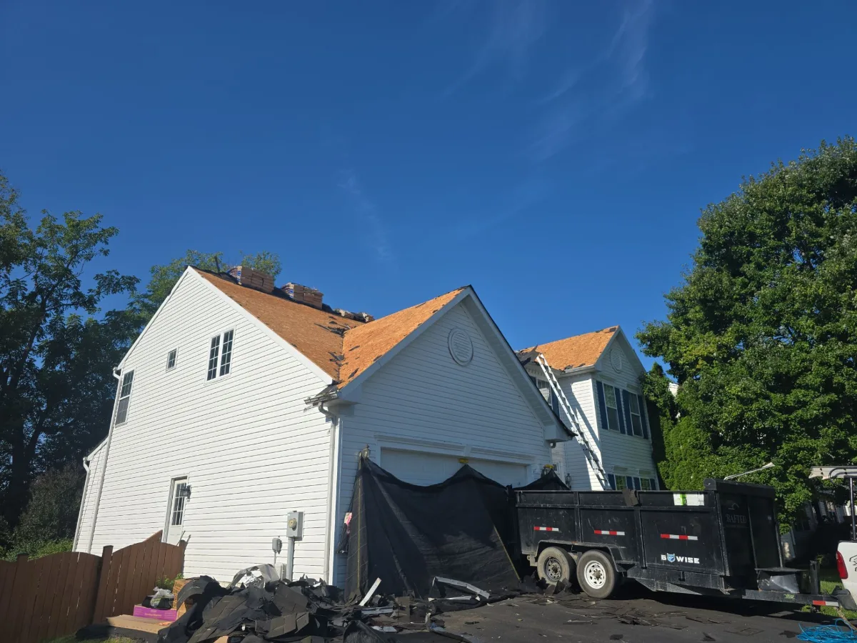 Old roof being torn off a two-story home in Charles Town, WV
