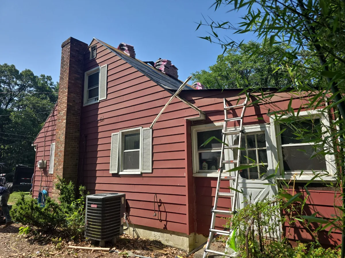 Old red siding on a Harpers Ferry, WV home before replacement