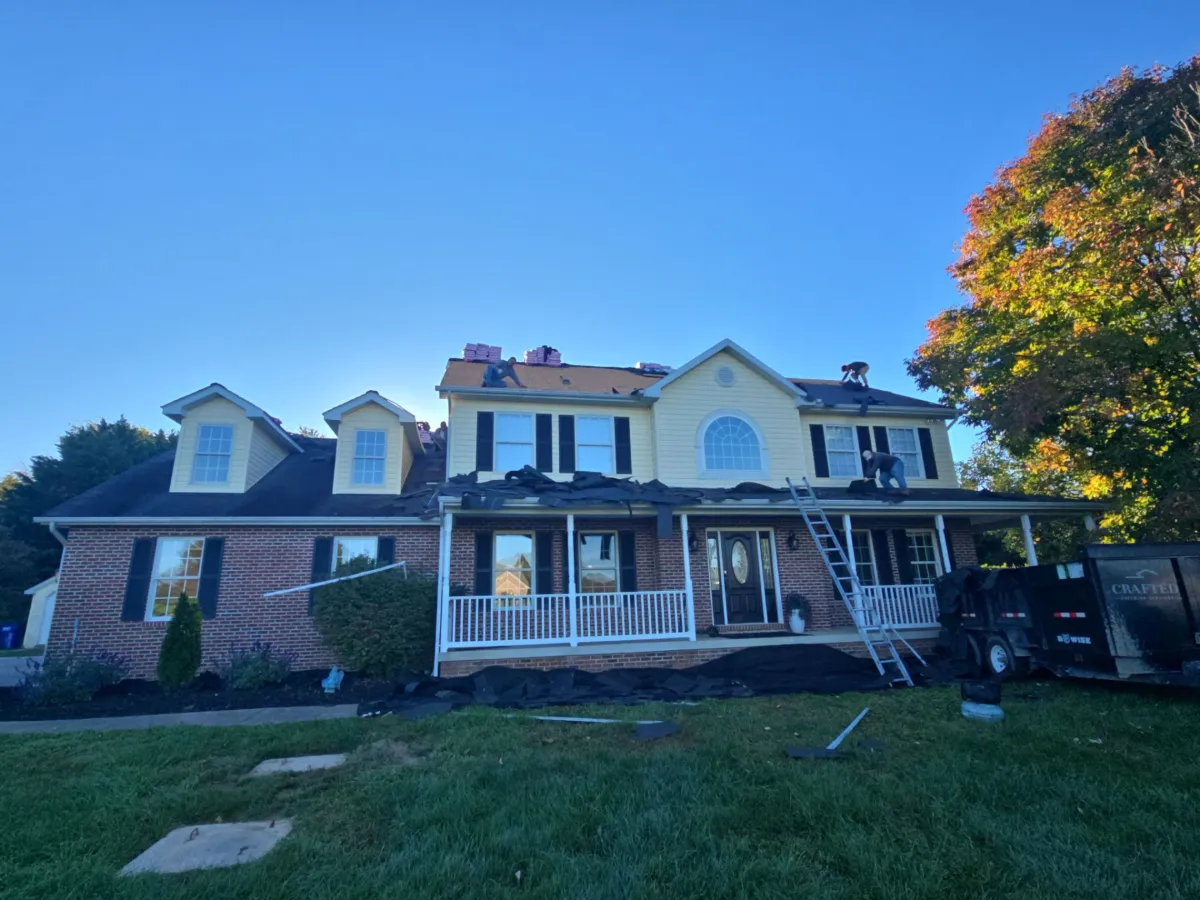 Two-story colonial with a front porch before the roof replacement in Keedysville, MD