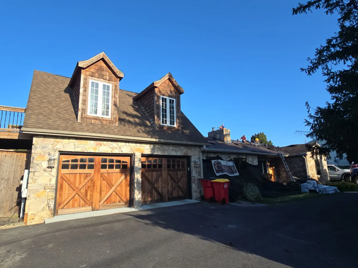 Stone ranch home and attached garage before the roof replacement in Martinsburg, WV